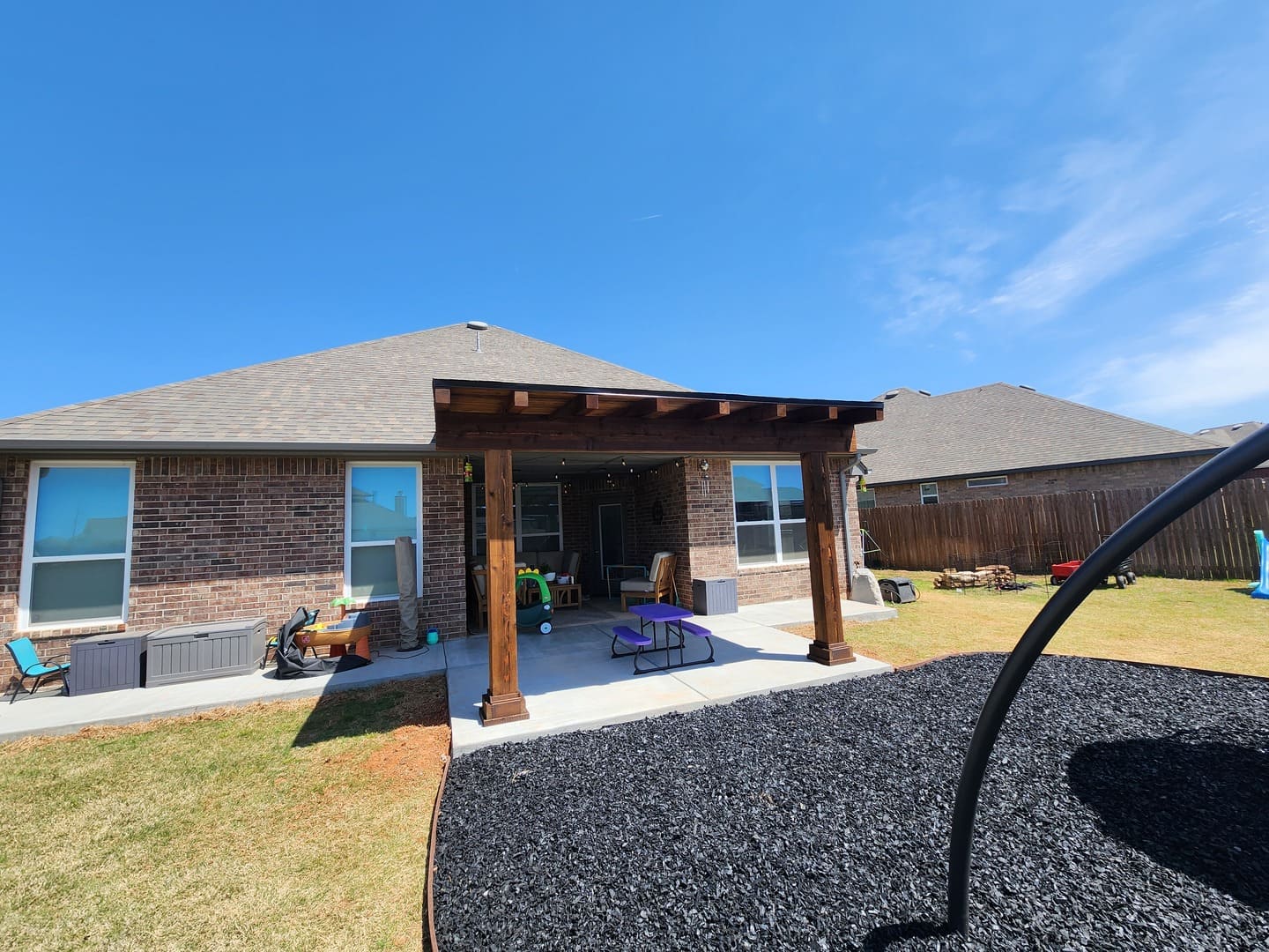 Backyard pergola patio installation with gravel landscape design in Oklahoma