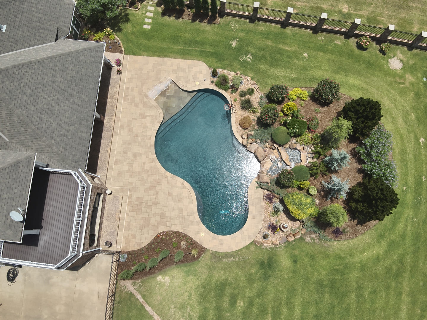 Backyard pool landscape design and installation with natural stone in Oklahoma