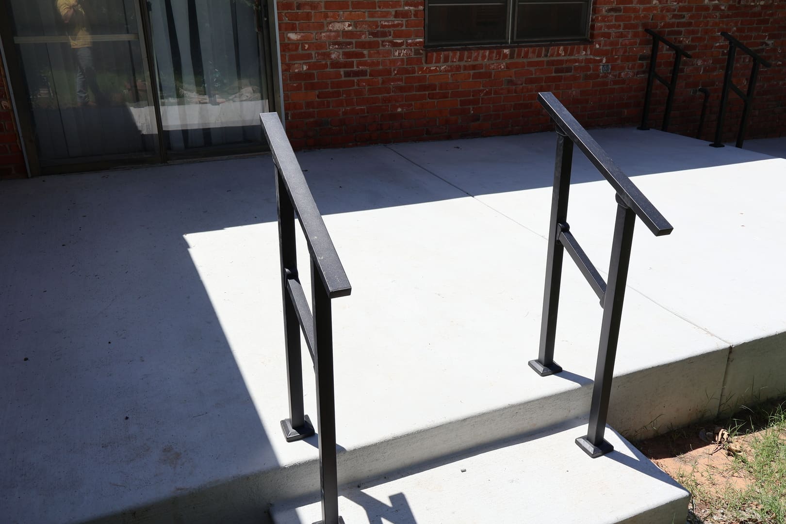 Concrete patio installation with accessibility handrails in Oklahoma