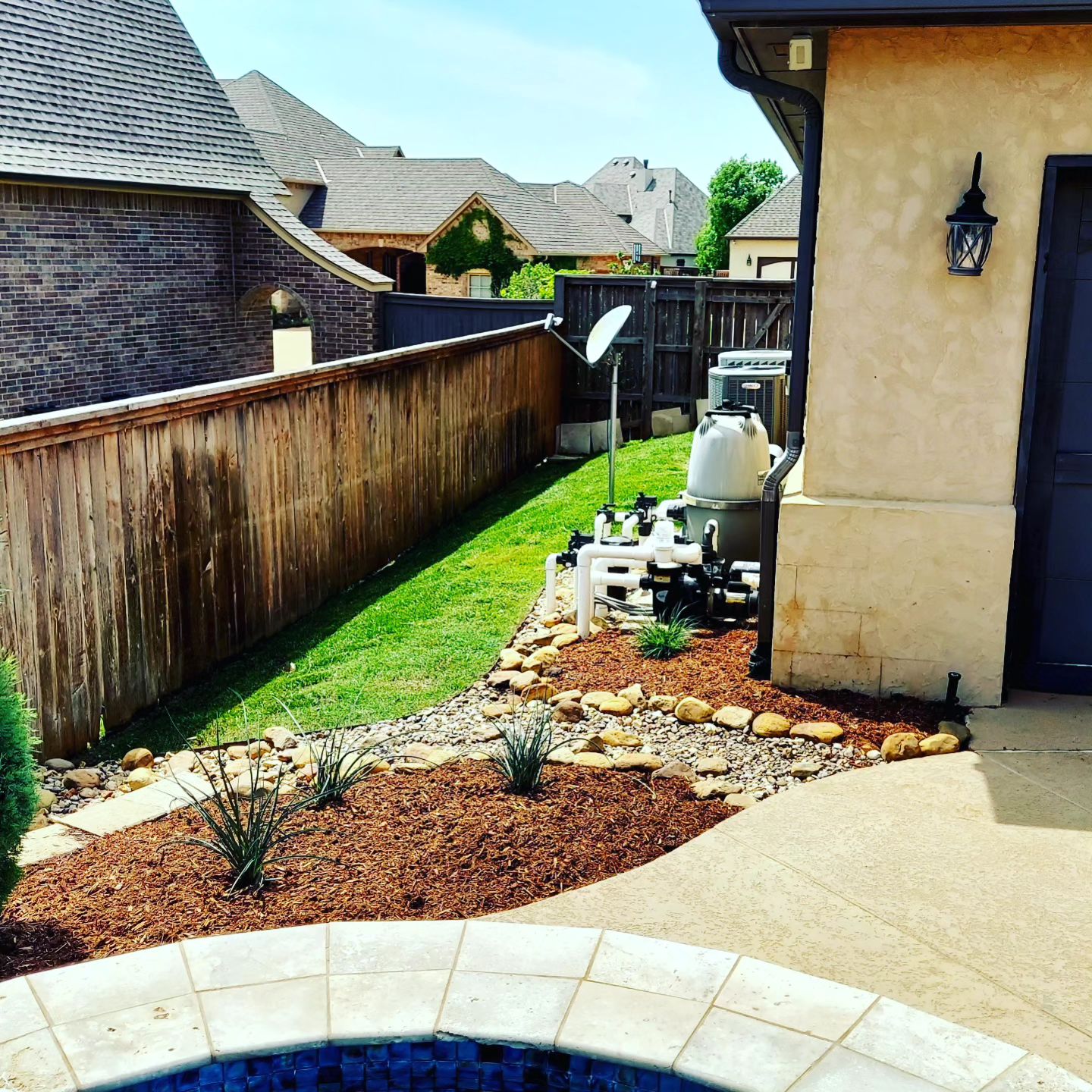 Existing wood fence beside a landscaped backyard bed