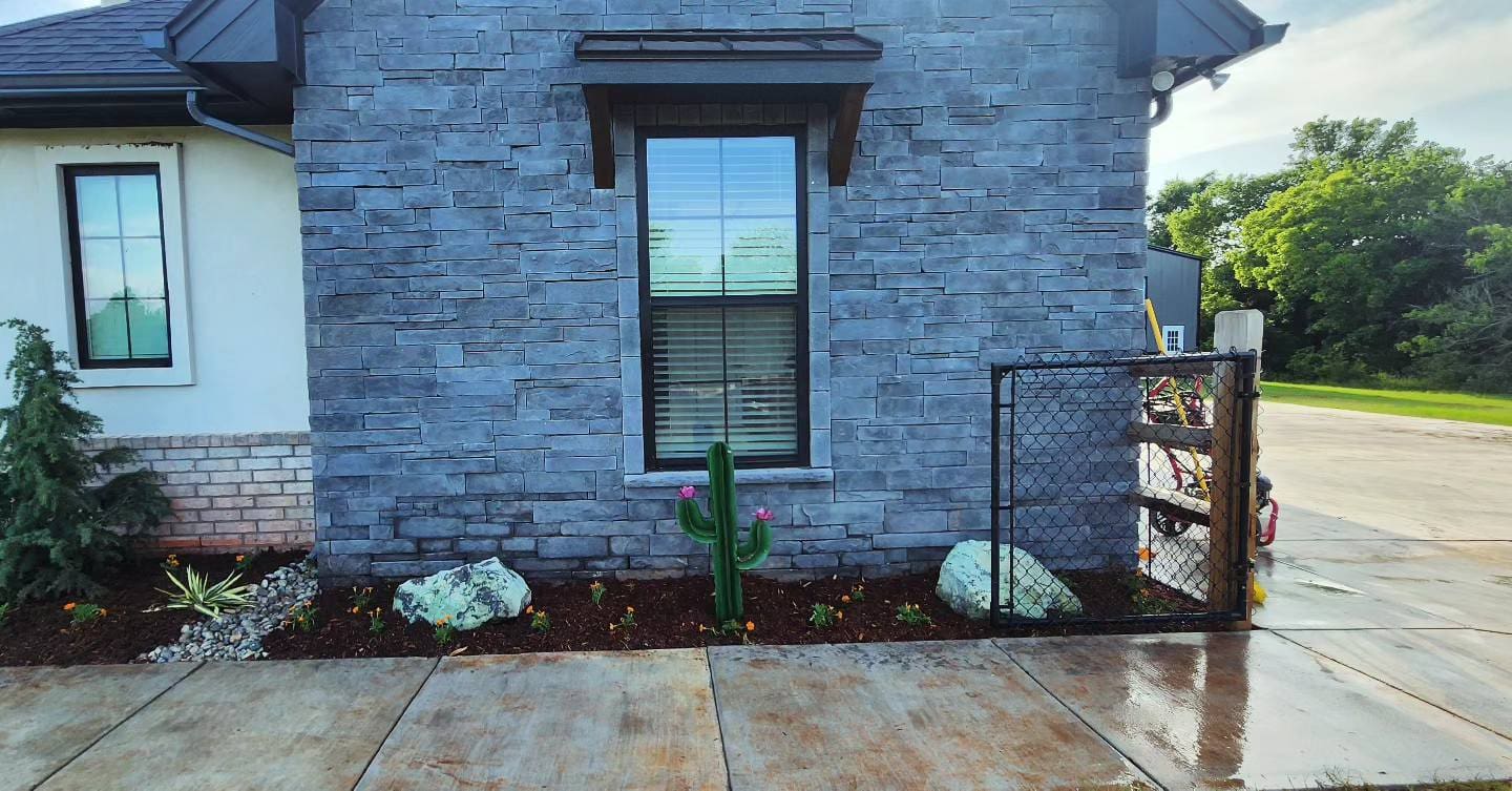 Front yard landscape planting with decorative rock accents in Oklahoma
