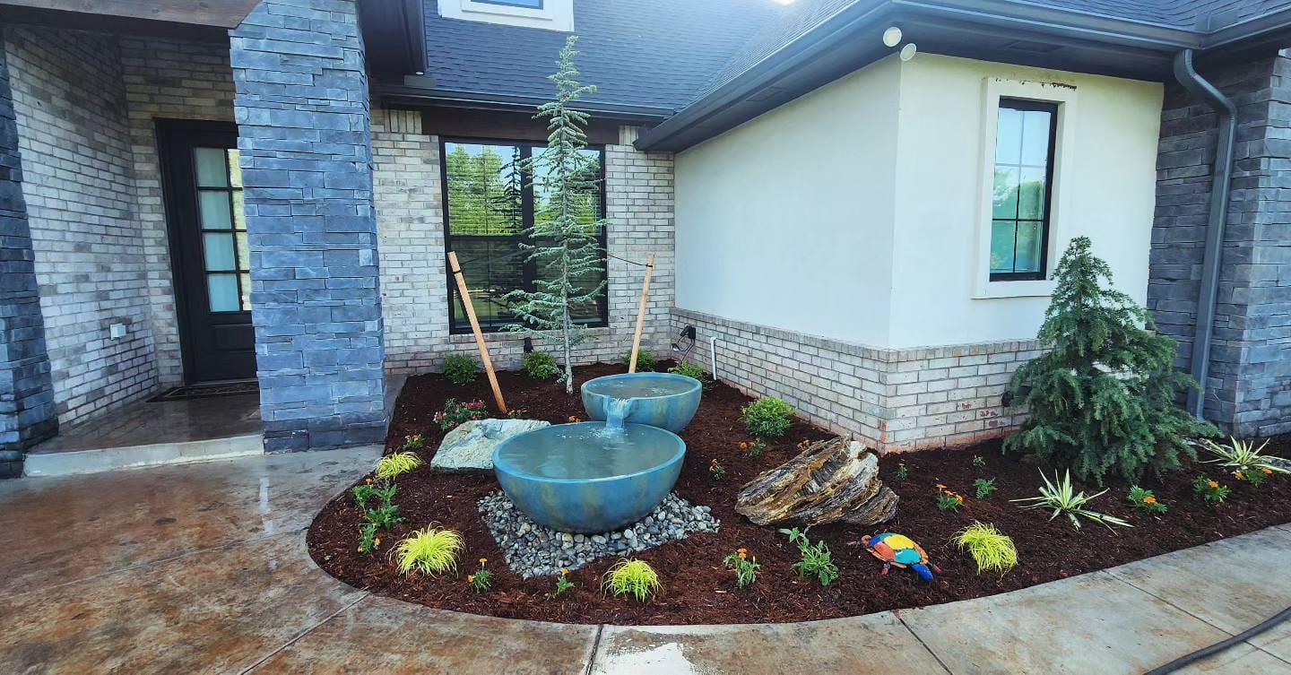 Front porch landscape design with decorative fountain and plants in Oklahoma