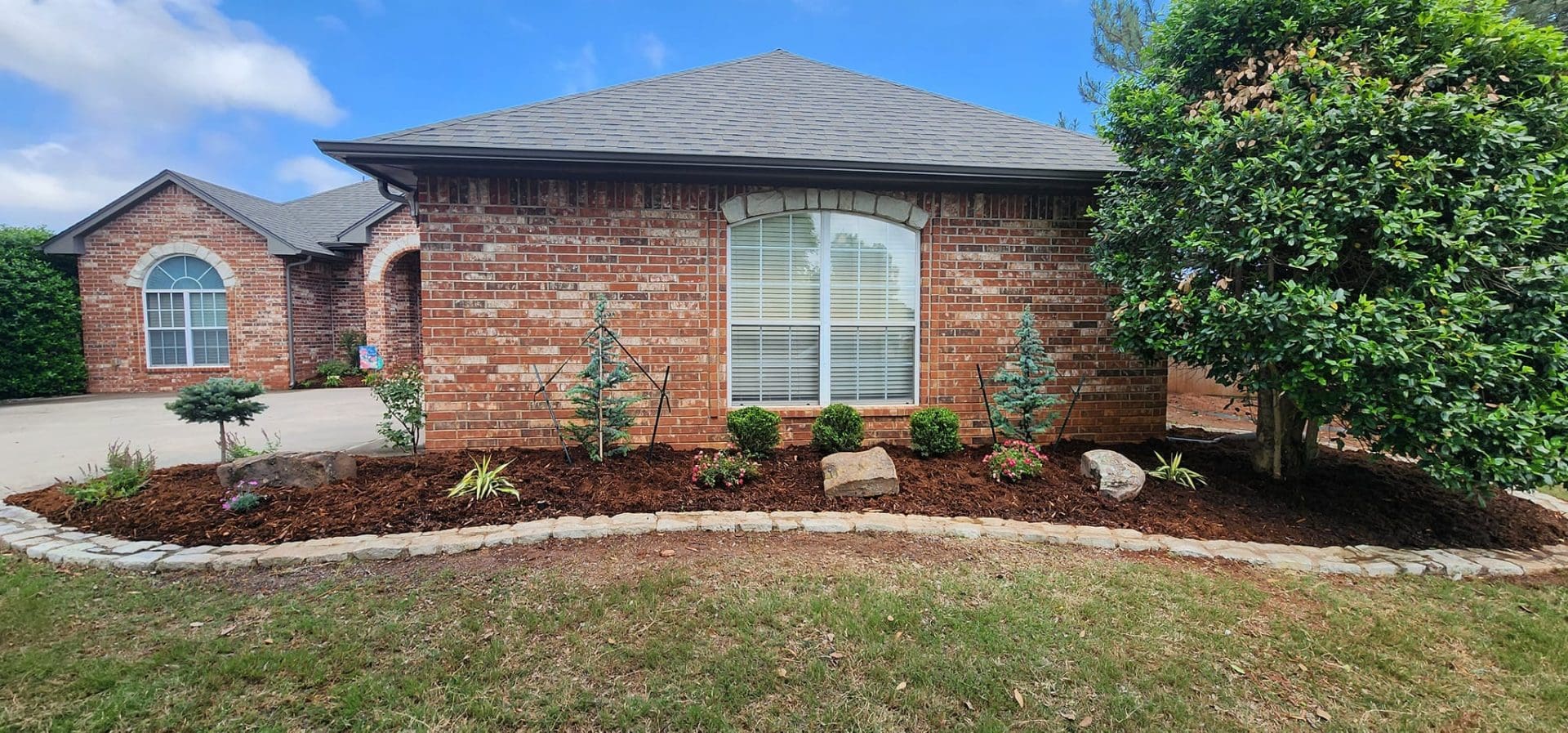 Front yard landscape planting with shrubs and mulch beds in Oklahoma