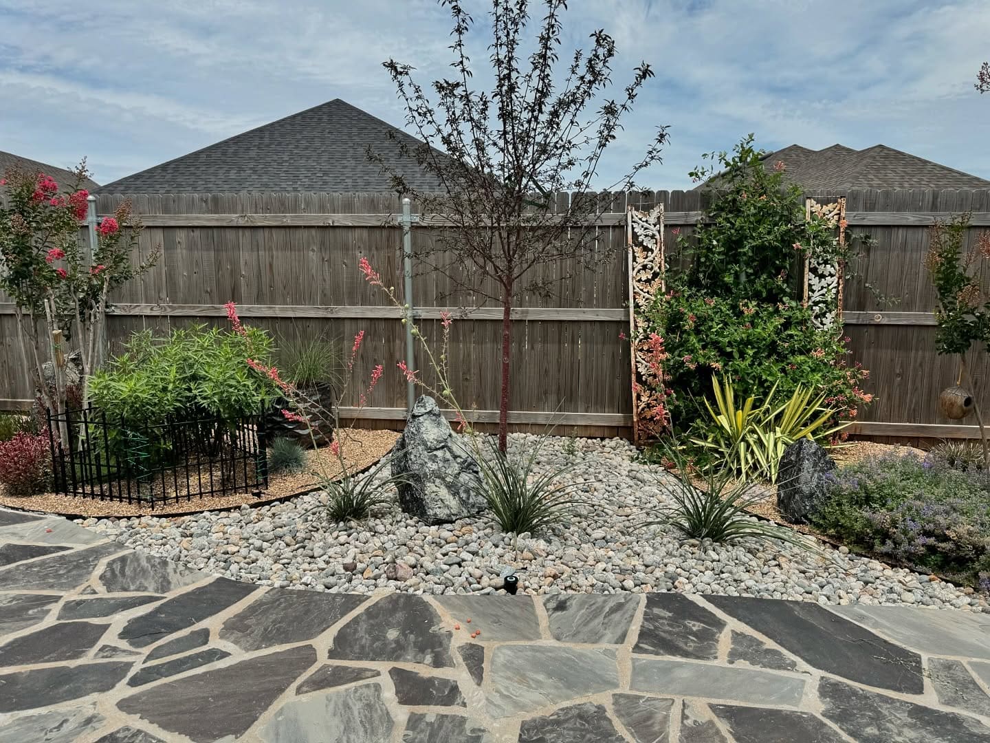 Flagstone patio installation with decorative rock landscaping in Oklahoma